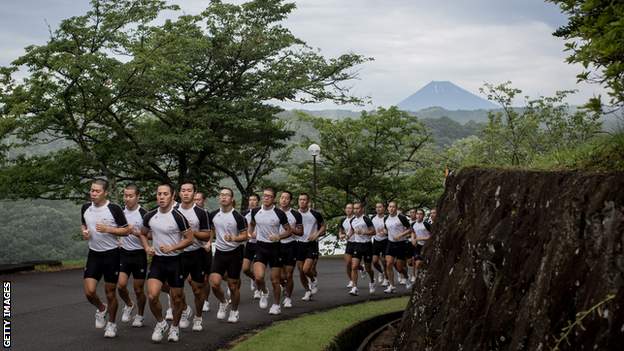 Mt. Fuji is seen in the background as keirin students run up a hill