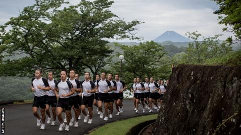 Mt. Fuji is seen in the background as keirin students run up a hill