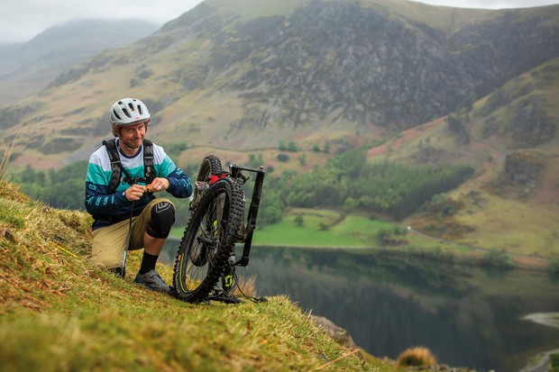 Repairing a puncture on a mountain bike at the side of a trail