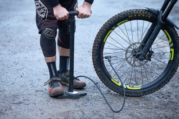 Pumping up a mountain bike tyre with a track pump
