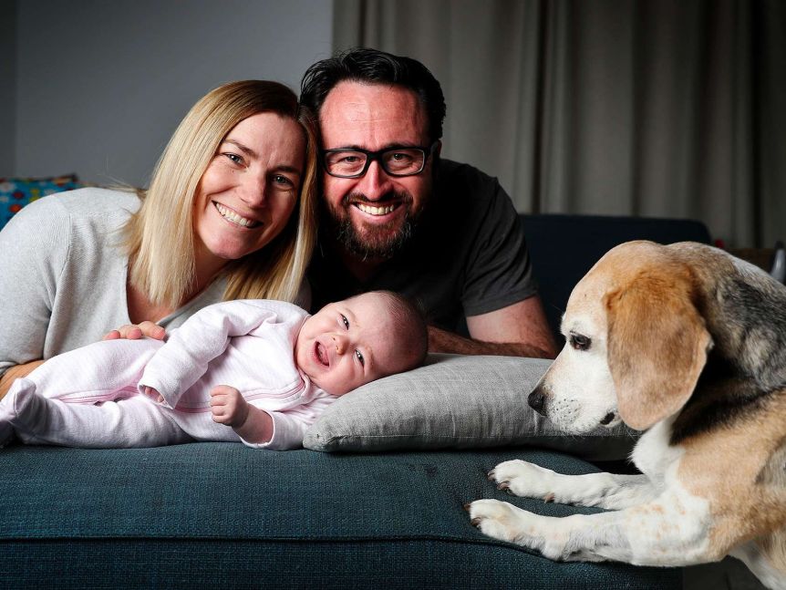 Anna, Nick and baby evelyn huddled together to the left with beagle Bruce in the right foreground.