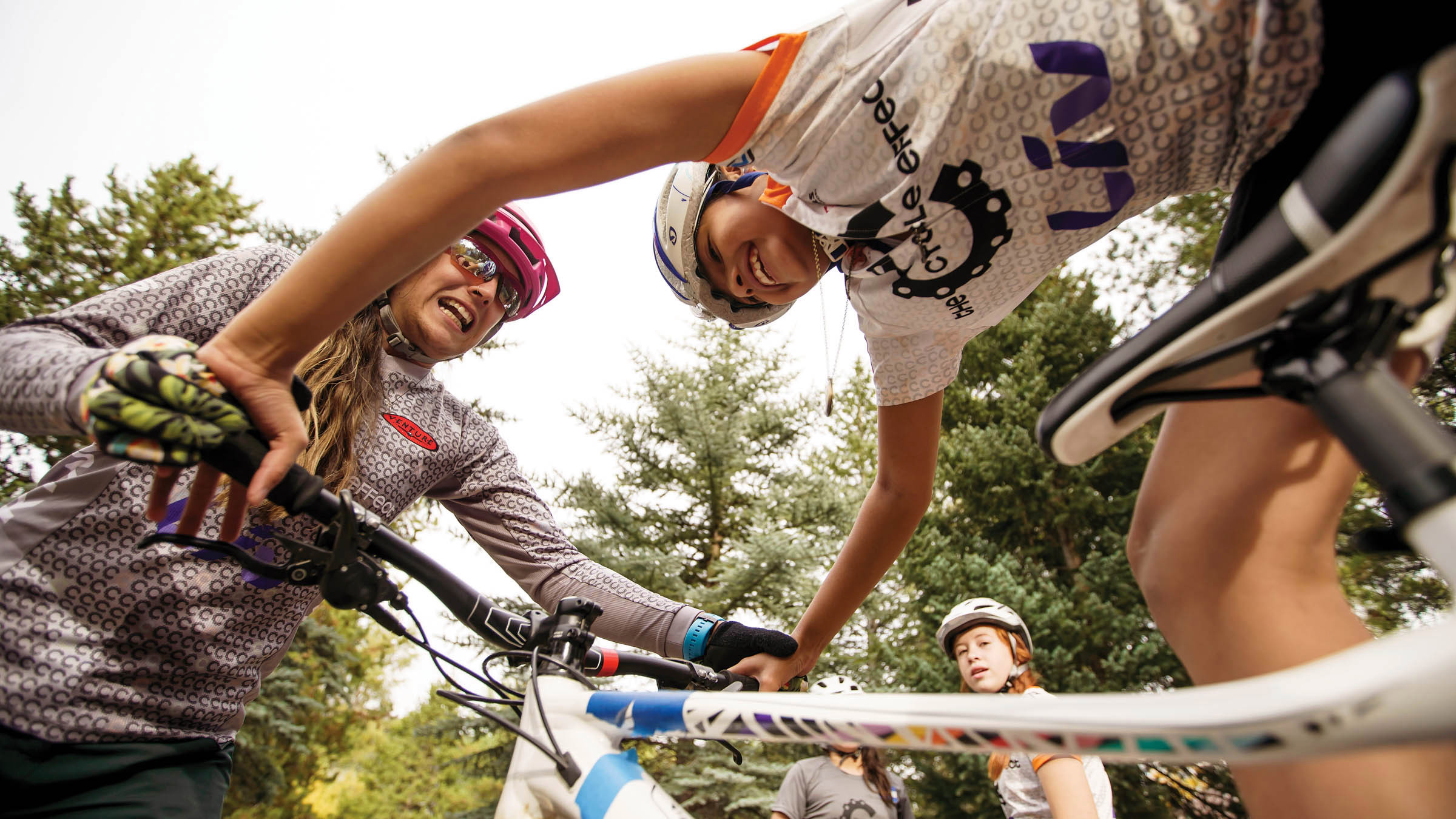 A woman grabs the handlebars of one of the girls' bikes