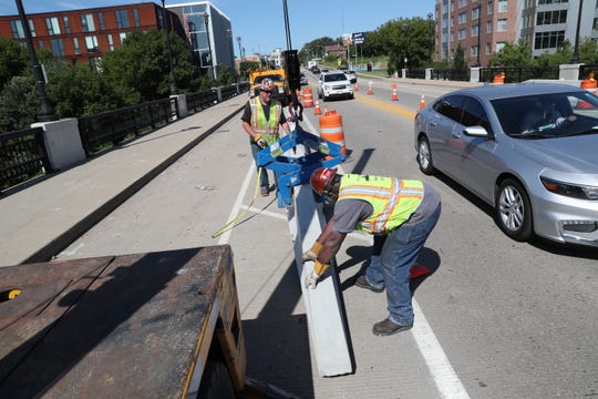 Kurt Rutkowski (rear) and Richard Jones install Jersey walls Thursday on the North Avenue bridge. New concrete barriers installed on two Milwaukee east side bridges will provide more protection for bike lanes.