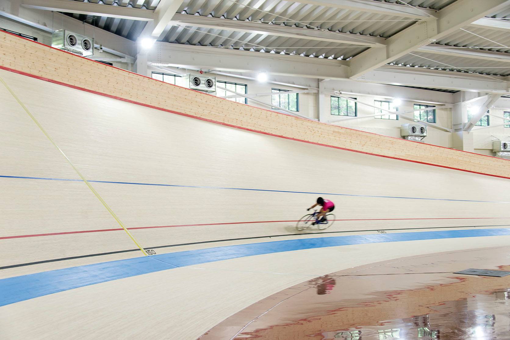 A keirin rider cycles around the bend of the velodrome inside Japan's only keirin school in the city of Izu, Shizuoka Prefecture, in August 2019. | ROB GILHOOLY