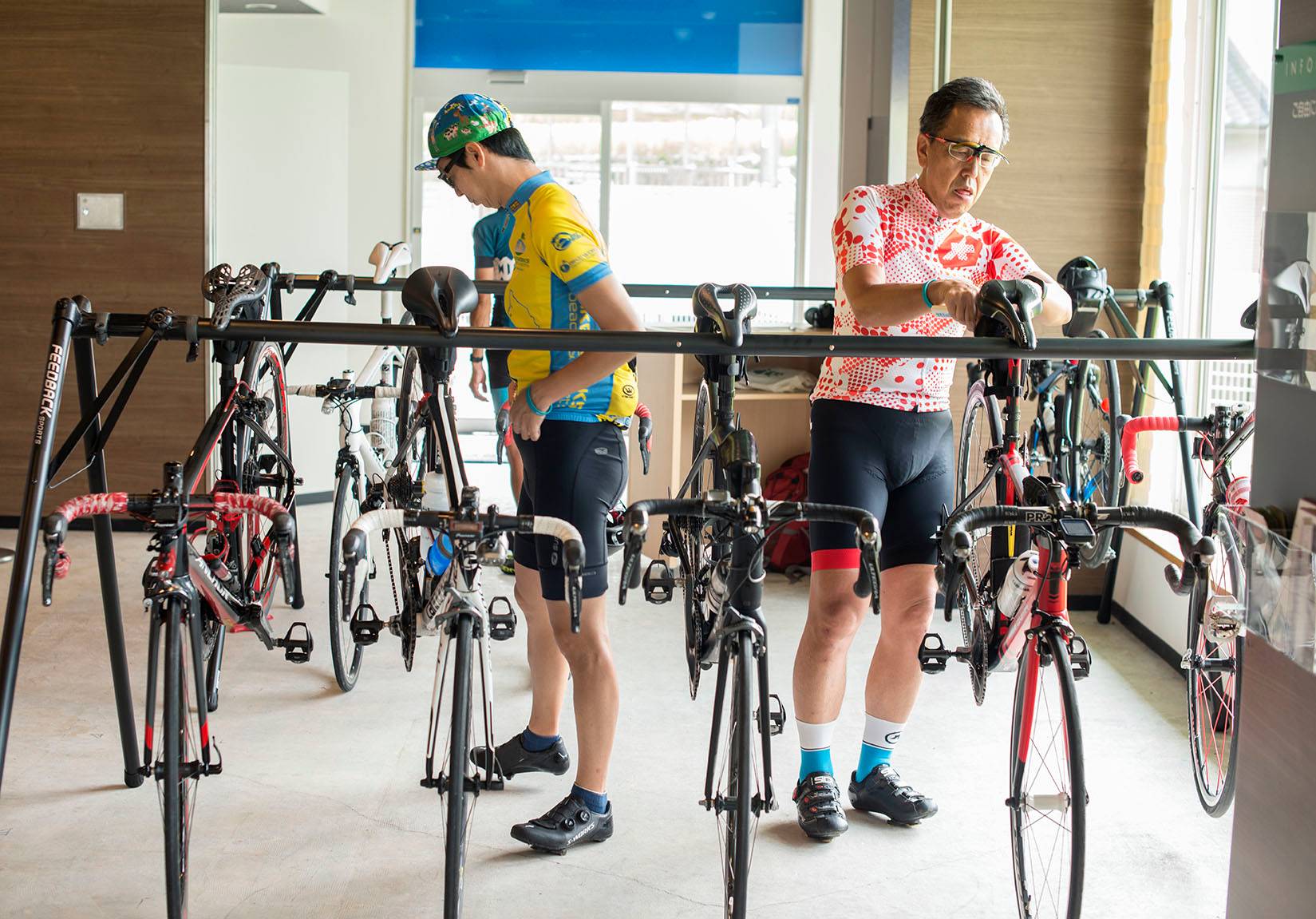Cyclists gather at Suruga Bank's cycle station before heading off on a 90-kilometer ride co-organized by the bank and the Izu Development Association in Izu City, Shizuoka Prefecture, in August 2019. | ROB GILHOOLY